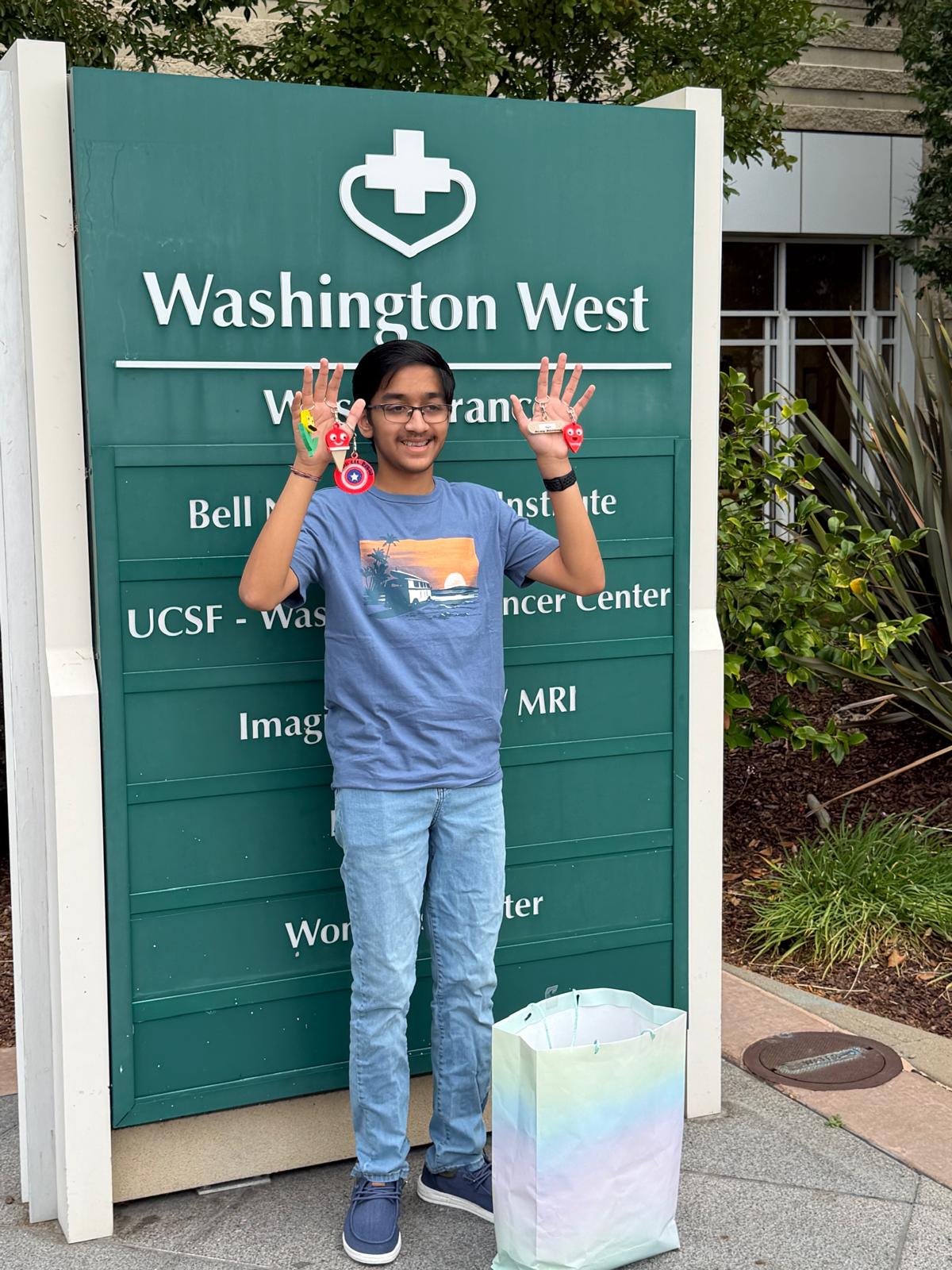 Vihaan outside Washington Hospital Fremont with donated 3D printed keychains